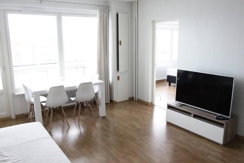 sala de estar con TV y mesa con sillas en Norden Homes City Centre 2-Bedroom Apartment + Free Parking, en Turku