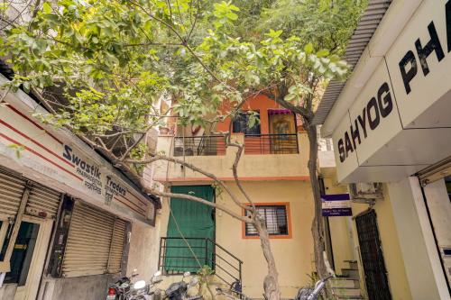 um edifício com uma porta verde e uma árvore em OYO New Knaha In em Aurangabad