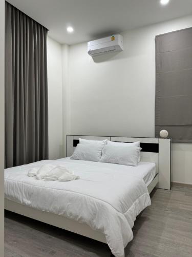 a bedroom with a large white bed with a white blanket at AKIRA Villa in Buriram
