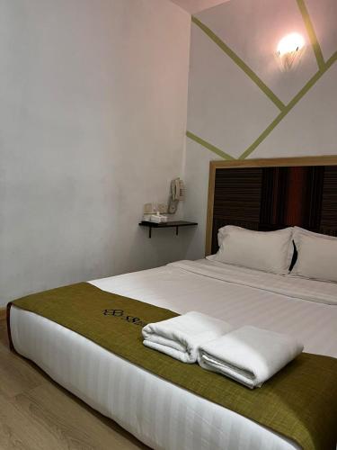 a bedroom with a bed with towels on it at S8 Boutique Hotel near KLIA 1 & KLIA 2 in Sepang