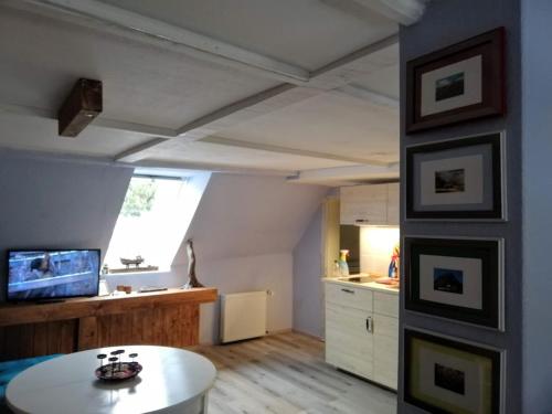 a living room with a table and a kitchen at Wohnung am Wanderweg zum Königsstuhl unter Reet in Lohme
