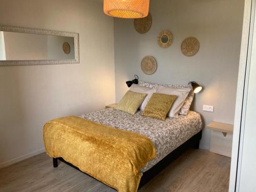 a bedroom with a bed with a yellow blanket on it at Appart'Hotel - Gare TGV - Courtine - Confluence - 202 in Avignon
