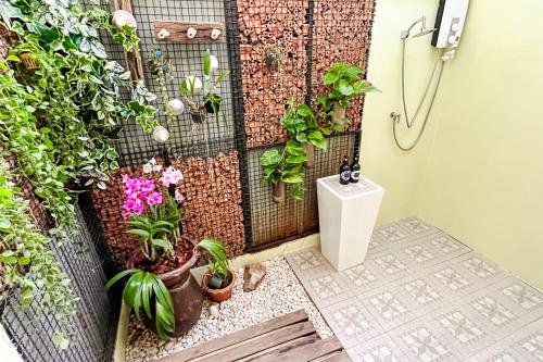 a bathroom with plants on the wall at Baan Bua Cottage SHA EXTRA PLUS B5510 in Ko Kood