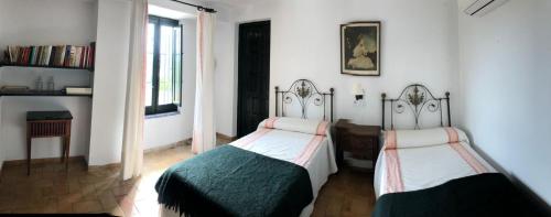 a bedroom with two twin beds and a window at La Capellania de Alvear in Montilla
