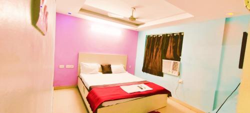um pequeno quarto com uma cama com paredes coloridas em Goroomgo Chandrabindu Near Sea Beach Puri em Puri