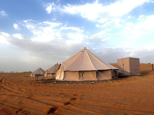una fila de tiendas en un campo desierto en Desert Stars Camp en Badīyah