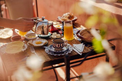 a table with a breakfast of tea and orange juice at Riad Bensaid in Marrakech