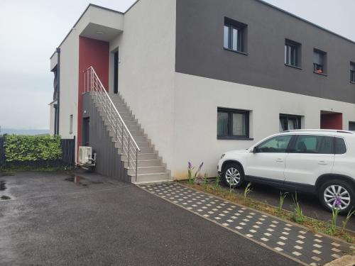 una furgoneta blanca estacionada frente a un edificio en Cocon zen et confortable à proximité de Colmar en Sundhoffen