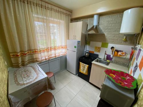 a small kitchen with a sink and a refrigerator at Гостевой дом «На Советов» in Yeysk