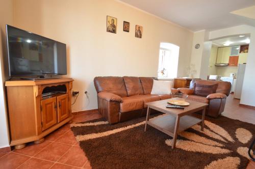 a living room with a couch and a flat screen tv at Dubravcevic Residence in Tivat
