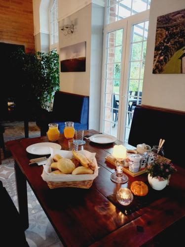 una mesa de madera con pan y vasos de zumo de naranja en Varga Villa en Orfű