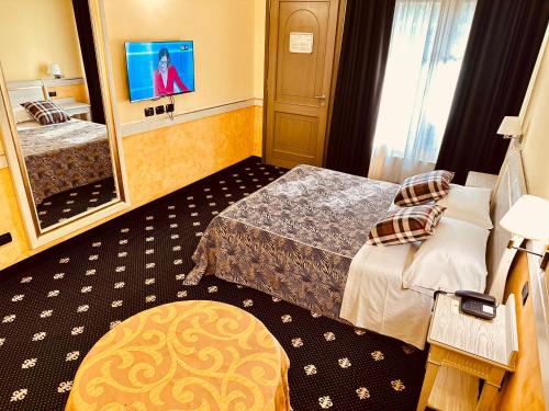 a hotel room with two beds and a mirror at MOTEL Malpensa INN & Hotel-Airport in Tornavento
