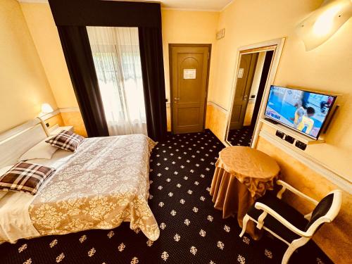 MOTEL Malpensa INN & Hotel-Airport في كازي نْووفي: غرفة فندقية بسرير وتلفزيون بشاشة مسطحة