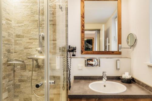 a bathroom with a sink and a shower at Torfhaus Harzresort in Torfhaus