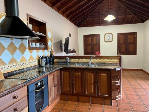 uma grande cozinha com um lavatório e um fogão em RUSTIC HOUSE LA MONTAÑA em Breña Baja