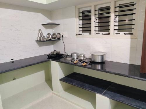 uma cozinha com um balcão com panelas e frigideiras em The Home Mars call 8O882-37972 em Mysore
