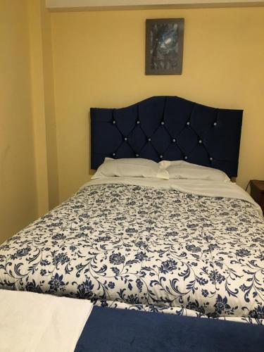 1 cama en un dormitorio con colcha azul y blanca en El Seminario Hospedaje en Cajamarca