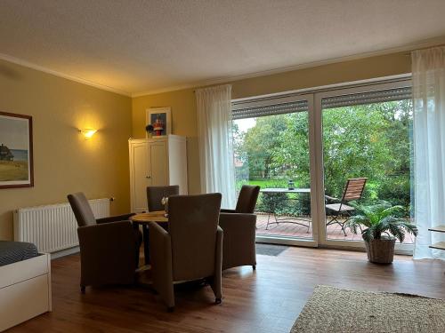 a dining room with a table and chairs and a large window at Ferienwohnung im Landhaus in Papenburg