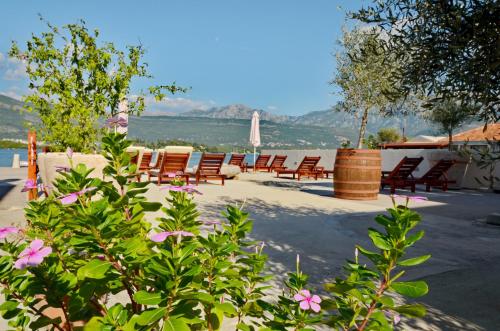 un grupo de sillas sentadas en un patio con flores en Apartments Dubravcevic, en Tivat