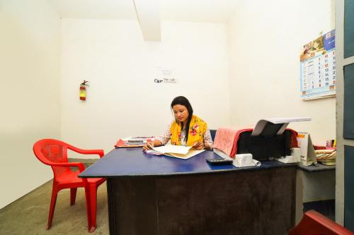 a woman sitting at a desk in an office at Hotel Famy Palace in Udalguri