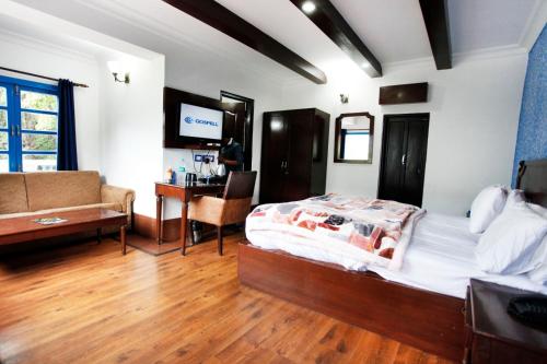a bedroom with a bed and a couch and a desk at Manu Maharani Regency in Nainital