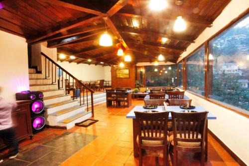 a restaurant with tables and chairs and a staircase at Manu Maharani Regency in Nainital