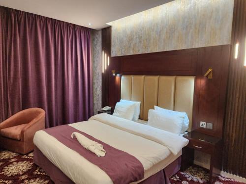 a hotel room with a large bed and a chair at EWG Al Hamra Hotel in Jeddah