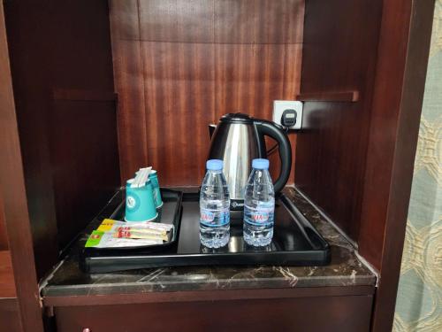 a tea kettle and two bottles of water on a tray at EWG Al Hamra Hotel in Jeddah