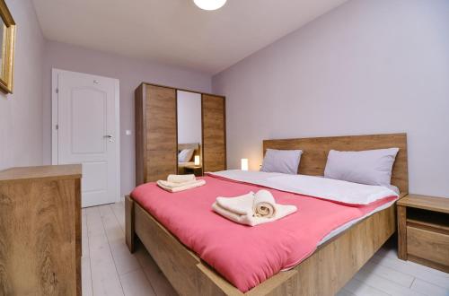 a bedroom with a large bed with two towels on it at Cozy 1-bed Apartment in Plovdiv