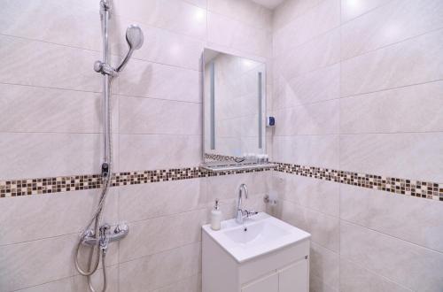 a white bathroom with a shower and a sink at Cozy 1-bed Apartment in Plovdiv