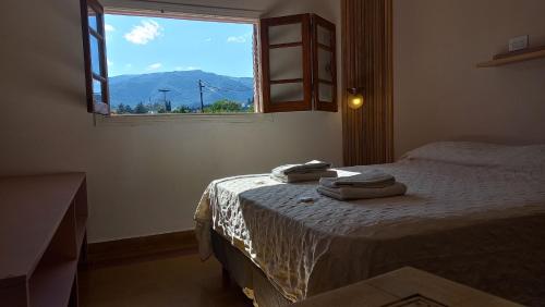 a bedroom with a bed with two towels on it at Holâ Hotel in La Falda