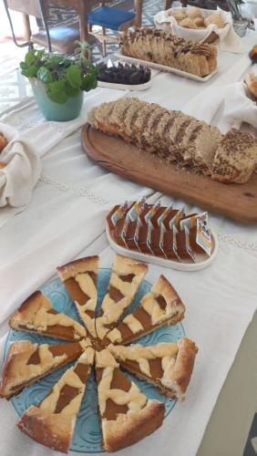 Una mesa con pan y pasteles sobre una mesa. en Holâ Hotel, en La Falda