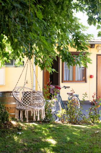 a swing hanging from a tree in front of a house at Motel-Restaurant 13 Etoiles in Saint-Léonard