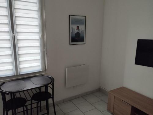 une chambre avec deux chaises, une table et une fenêtre dans l'établissement charmant studio canapé lit Netflix prime vidéo Dazn wifi, au Havre