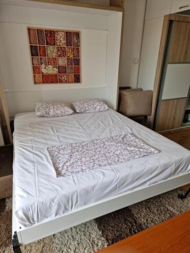 a bed with two pillows on it in a bedroom at Studio Apartment Ena S in Sarajevo