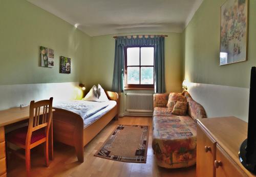 mały pokój z łóżkiem i kanapą w obiekcie Gasthof zur Bruthenne w mieście Weissenbach an der Triesting