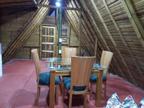 a dining room with a table and chairs in a attic at Preciosa Cabaña alpina en zona rural in Dosquebradas