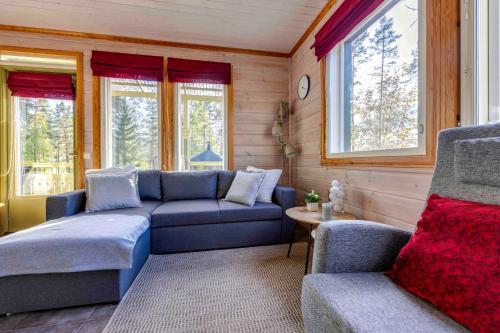 ein Wohnzimmer mit Sofas, einem Tisch und Fenstern in der Unterkunft Lomahuvila Himoksen Pistaasi in Jämsä