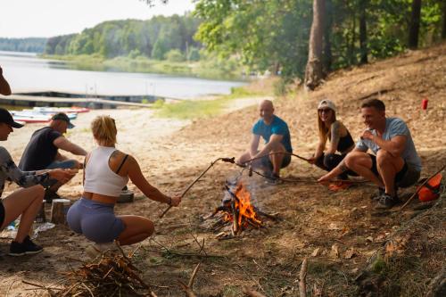 a group of people sitting around a campfire at TO TU Chańcza Mały Domek z Balią in Raków