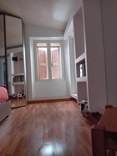 an empty living room with a mirror and wooden floors at La Maison Dell'Amour in Boville Ernica