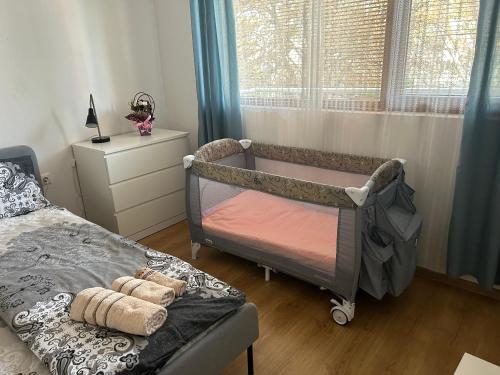 1 dormitorio con 1 cama, vestidor y ventana en АПАРТАМЕНТ МАЯ с две спални en Kazanlŭk