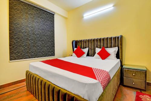 a bedroom with a large bed with red pillows at Flagship Hotel White Hut in Delhi