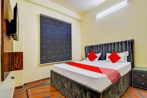 a bedroom with a bed with red pillows and a window at Flagship Hotel White Hut in Delhi