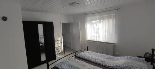 a bedroom with a bed and a window at Blu Home/Ferienwohnung in Ostrach
