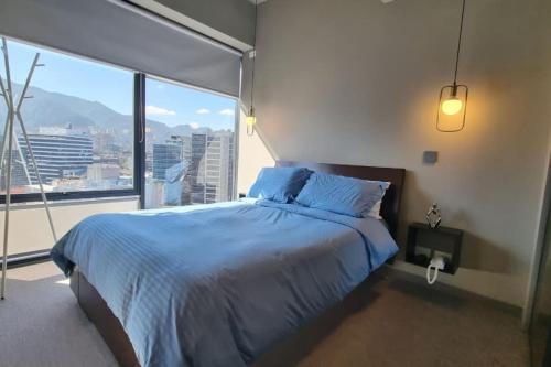 ein Schlafzimmer mit einem großen Bett und einem großen Fenster in der Unterkunft Bright luxurious flat with stunning view workspace in Bogotá
