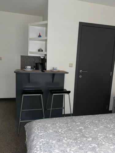 a bedroom with a black desk and a counter with stools at Impasse 3 in Fosses-La-Ville
