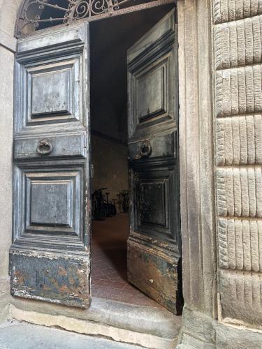 uma porta aberta com duas velhas portas de madeira em In Centro Lovely Home em Lucca