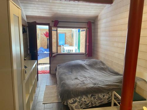 um pequeno quarto com uma cama e uma janela em Studio indépendant au calme à Biarritz em Biarritz