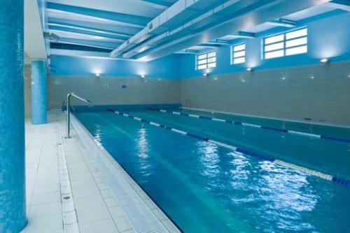 a large swimming pool in a large building at Royal Place 2 bedrooms Apartment Wilanów in Warsaw