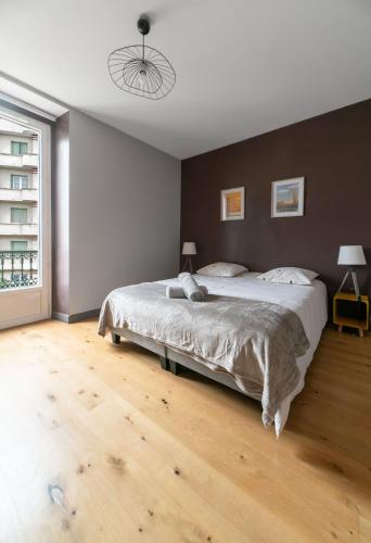 une chambre avec un grand lit et un parquet dans l'établissement Le Gramont - Grand appartement design, 3 chambres, Centre Ville, à Vichy